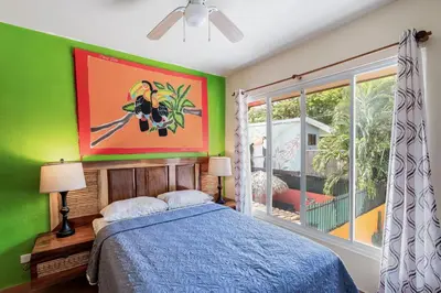 a bedroom with a bed and a painting on the wall at Charming Duplex in Playa Potrero Surfside Community, with a Private Pool, Cozy Interior and Walkable Access to the Beach in Potrero