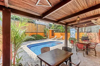 a patio with a table and chairs and a pool at Charming Duplex in Playa Potrero Surfside Community, with a Private Pool, Cozy Interior and Walkable Access to the Beach in Potrero