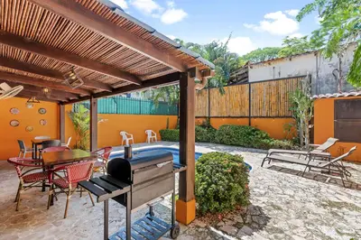 a patio with a grill and a table and chairs at Charming Duplex in Playa Potrero Surfside Community, with a Private Pool, Cozy Interior and Walkable Access to the Beach in Potrero