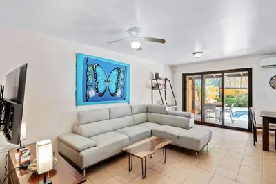 a living room with a couch and a tv at Charming Duplex in Playa Potrero Surfside Community, with a Private Pool, Cozy Interior and Walkable Access to the Beach in Potrero