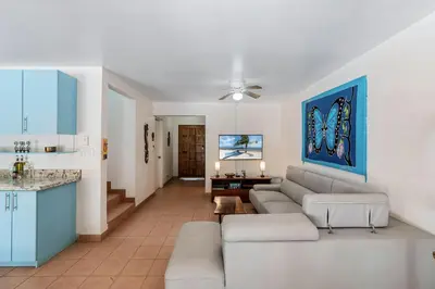 a living room with a couch and a kitchen at Charming Duplex in Playa Potrero Surfside Community, with a Private Pool, Cozy Interior and Walkable Access to the Beach in Potrero
