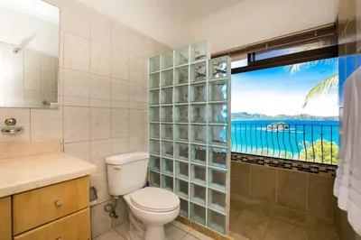 a bathroom with a toilet and a view of the ocean at Beautiful Condo in Peaceful Cliffside Location with a Private Balcony & Stunning Ocean and Mountain Views in Playa Flamingo