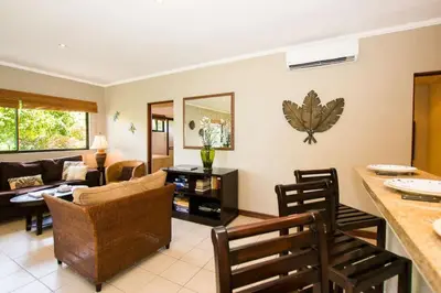 a living room with a couch and a table at Beautiful Condo in Peaceful Cliffside Location with a Private Balcony & Stunning Ocean and Mountain Views in Playa Flamingo