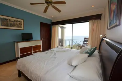 a bedroom with a large bed with a large window at Fifth-Floor Condo with Breathtaking Ocean Views, Stylish Interior & Prime Location Near Flamingo Beach in Playa Flamingo