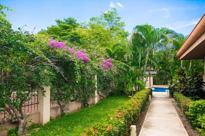 a garden with flowers and a swimming pool at Cozy Ground-Floor Condo with Community Pool, Rancho and Lush Garden Views in Brasilito