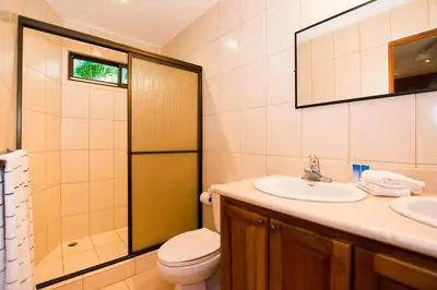 a bathroom with a sink and a toilet and a mirror at Cozy Ground-Floor Condo with Community Pool, Rancho and Lush Garden Views in Brasilito