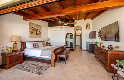 a bedroom with a bed and a desk and a television at Upscale Two-Bedroom Condo in Playa Flamingo with Beautiful Oceanfront Views in Playa Flamingo