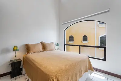 a bedroom with a bed and a large window at Top-Floor Condo with Sweeping Ocean, Mountain & Marina Views in Playa Flamingo