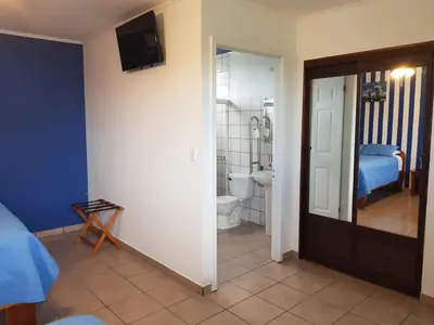 a room with a bathroom with a bed and a toilet at Hotel Grosseto Palma Real in Loma