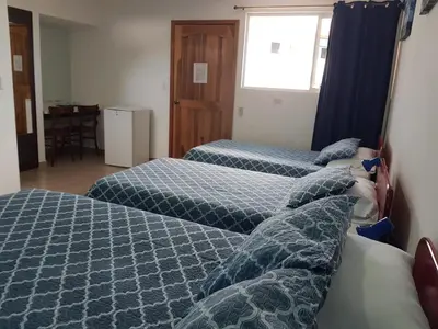 a hotel room with three beds and a window at Hotel Grosseto Palma Real in Loma