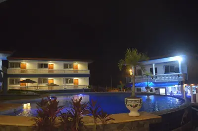 a house and a swimming pool at night at Hotel Grosseto Palma Real in Loma