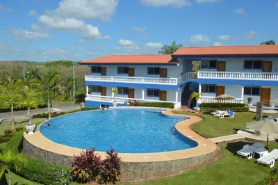 a house with a large swimming pool in front of it at Hotel Grosseto Palma Real in Loma