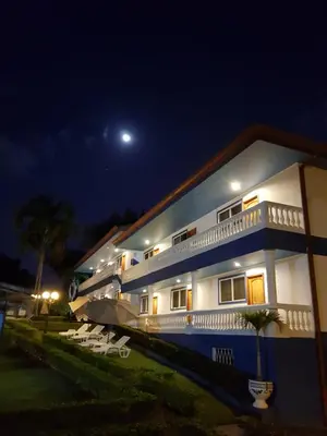a house at night with the moon in the sky at Hotel Grosseto Palma Real in Loma