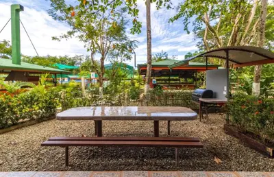 a picnic table and an umbrella in a park at Hotel Cabinas el Tecal in Uvita