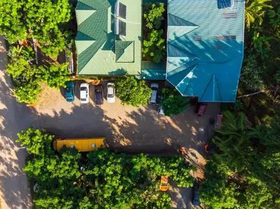 an overhead view of a group of cars parked next to a house at Hotel Cabinas el Tecal in Uvita