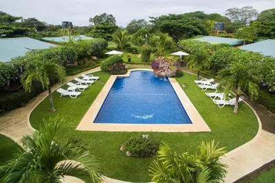 an overhead view of a swimming pool with white lounge chairs at Playa Potrero Apartments in Potrero