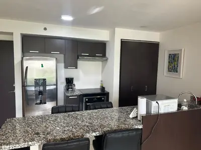 a kitchen with a counter top and a kitchen with a refrigerator at Charming Two Bedroom with balcony in San José