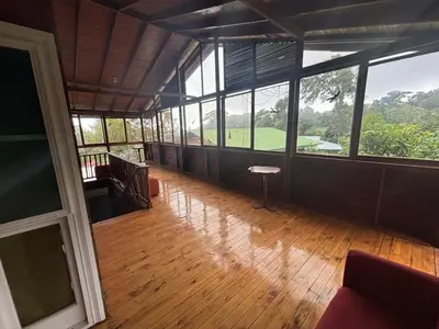 an empty room with a view of a golf course at Hotel Bosque Verde Lodge in Monteverde Costa Rica