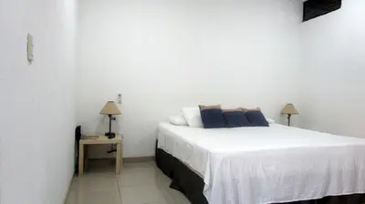 a bedroom with a bed and a table with two lamps at Sueño Tranquilo in Quepos