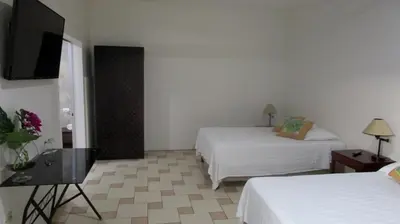 a hotel room with two beds and a flat screen tv at Sueño Tranquilo in Quepos