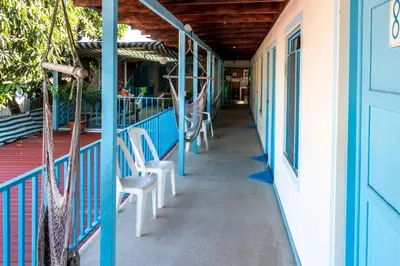a porch of a building with chairs on it at Hostel Samara in Sámara