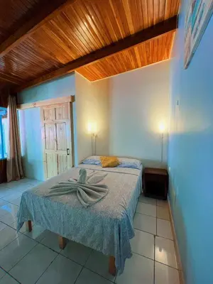 a bedroom with a bed with a towel on it at Hostel Samara in Sámara