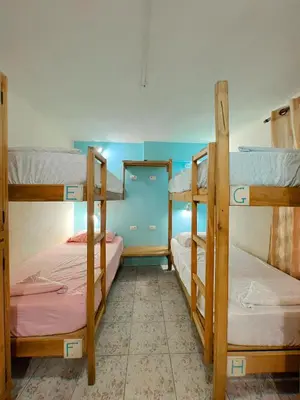 a bedroom with three bunk beds in a room at Hostel Samara in Sámara