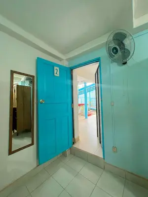 a room with a blue door and a fan at Hostel Samara in Sámara