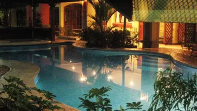 a large swimming pool with lights in a building at Hotel Iguana Verde in Orotina