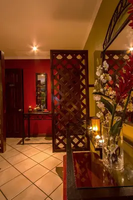 a room with a wine rack and a vase of flowers at Hotel Iguana Verde in Orotina