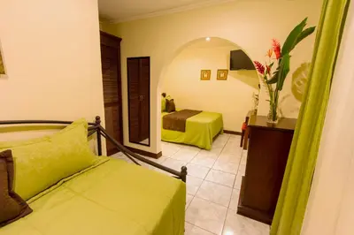 a hotel room with two beds and a mirror at Hotel Iguana Verde in Orotina