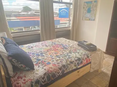 a bedroom with a bed with a pillow and a window at Sofia Apartments in Escalante, San Jose Center in San José