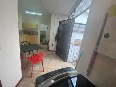 a room with a kitchen and a table with a washing machine at Sofia Apartments in Escalante, San Jose Center in San José