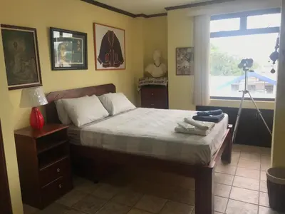 a bedroom with a large bed and a window at Sofia Apartments in Escalante, San Jose Center in San José