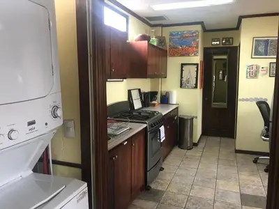 a kitchen with a stove top oven next to a hallway at Sofia Apartments in Escalante, San Jose Center in San José