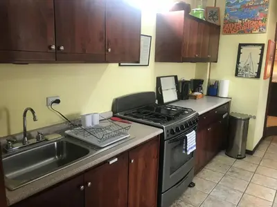 a kitchen with a stove top oven next to a sink at Sofia Apartments in Escalante, San Jose Center in San José