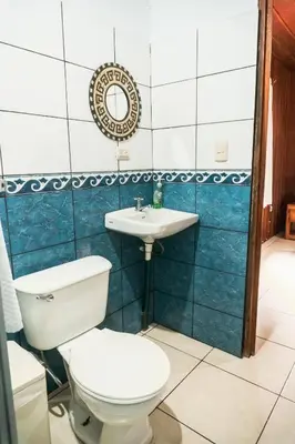 a bathroom with a toilet and a sink at Cabinas Lupita in Fortuna