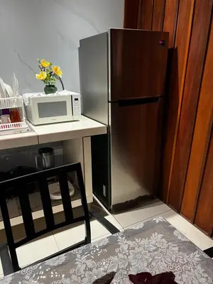 a kitchen with a microwave and a refrigerator at Cabinas Lupita in Fortuna