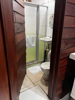 a bathroom with a toilet and a sink at Cabinas Lupita in Fortuna