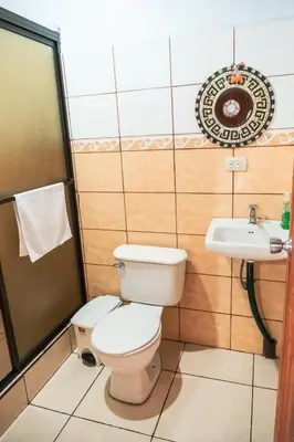 a bathroom with a toilet and a sink at Cabinas Lupita in Fortuna