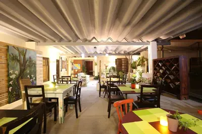 a dining room with tables and chairs and a room with wine bottles at Casa María Aeropuerto B&B in Alajuela City