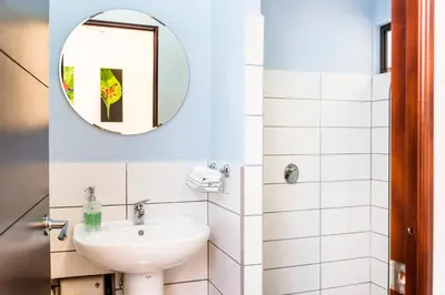 a bathroom with a sink and a mirror at Casa María Aeropuerto B&B in Alajuela City