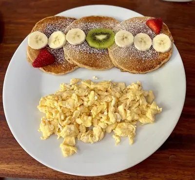 a plate of breakfast foods with eggs and fruit at Dreams Lodge in Monteverde Costa Rica