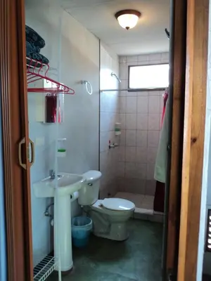 a bathroom with a toilet and a sink and a shower at Cabinas Dormi Bene in Miramar