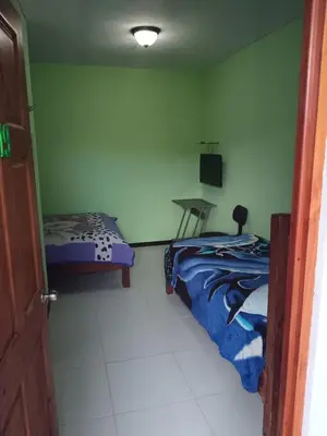 a bedroom with two beds and a table in it at Cabinas Dormi Bene in Miramar