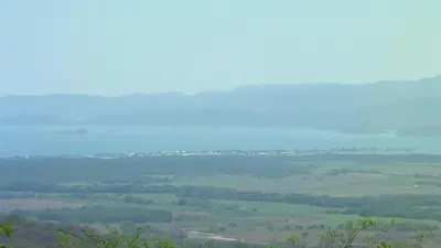 a view of a field with mountains in the distance at Cabinas Dormi Bene in Miramar