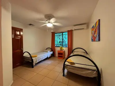 a room with two bunk beds and a window at Wipeout Guest House in Jacó