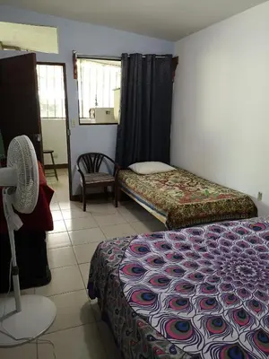 a room with two beds and a chair in it at Blue Morpho House B&B in Manuel Antonio