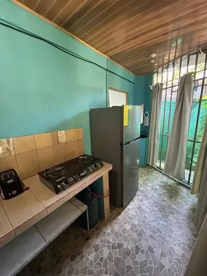 a kitchen with a stove and a refrigerator at Blue Morpho House B&B in Manuel Antonio