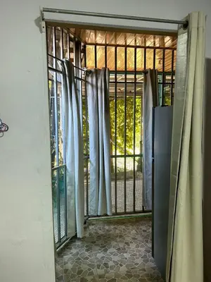 an open door with a gate with curtains at Blue Morpho House B&B in Manuel Antonio
